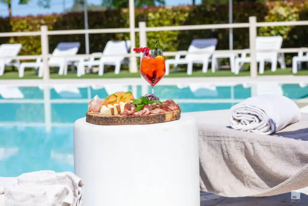 Rilassati accanto alla nostra infinity pool, gustando un aperitivo colorato e squisiti salumi.