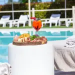 Rilassati accanto alla nostra infinity pool, gustando un aperitivo colorato e squisiti salumi.